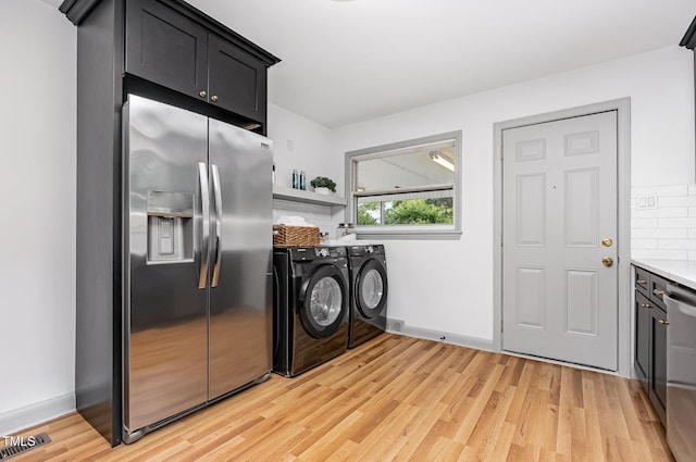 2205 W Carver St, Durham, NC 27705 - laundry room with separate washer and dryer, cabinet space, light wood-style flooring, and baseboards