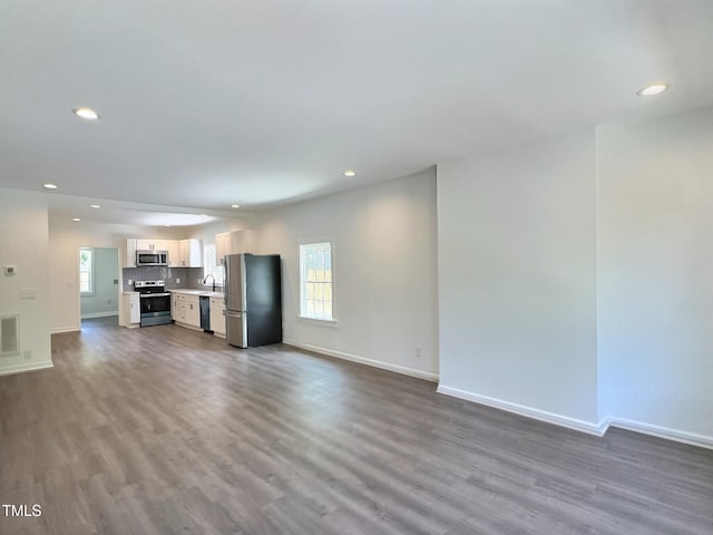 114 N Guthrie Ave, Durham, NC 27703 - unfurnished living room with recessed lighting, dark wood finished floors, and baseboards