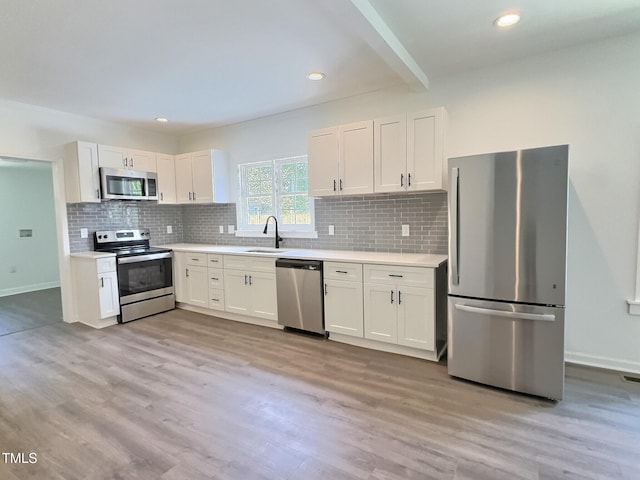 114 N Guthrie Ave, Durham, NC 27703 - kitchen with stainless steel appliances, a sink, light wood-style flooring, beamed ceiling, and recessed lighting