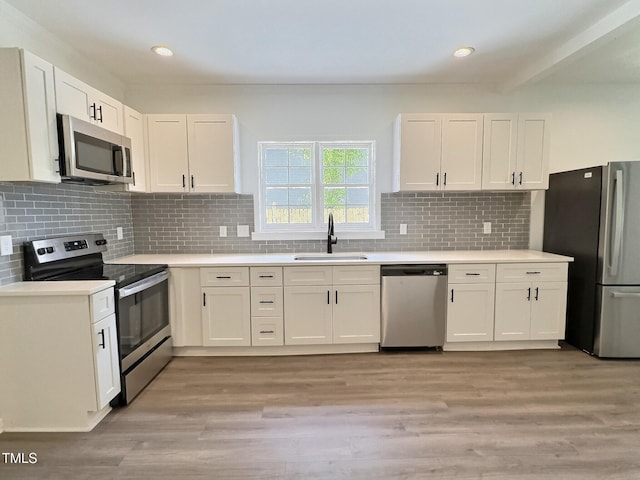114 N Guthrie Ave, Durham, NC 27703 - kitchen with appliances with stainless steel finishes, a sink, white cabinets, light countertops, and recessed lighting