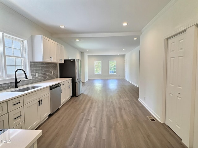 114 N Guthrie Ave, Durham, NC 27703 - kitchen with stainless steel appliances, a sink, baseboards, tasteful backsplash, and white cabinetry