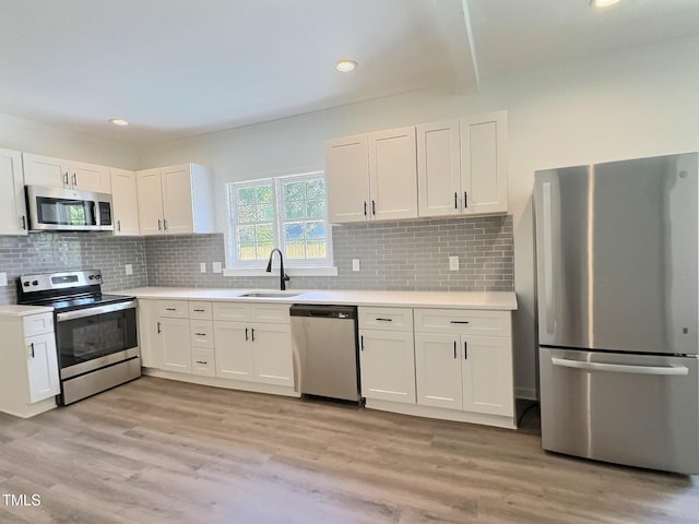 114 N Guthrie Ave, Durham, NC 27703 - kitchen with stainless steel appliances, a sink, white cabinets, light countertops, and recessed lighting