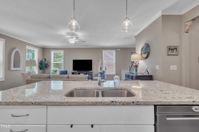 kitchen featuring a sink, ornamental molding, open floor plan, ceiling fan, and light stone countertops
