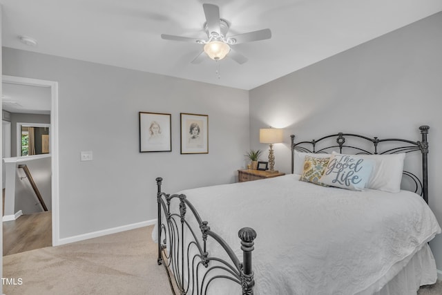 bedroom featuring light carpet, baseboards, and ceiling fan