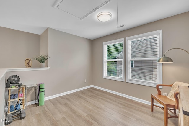 sitting room featuring attic access, wood finished floors, and baseboards