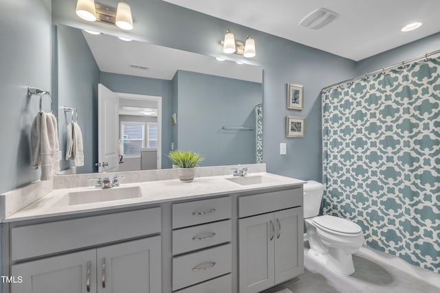 full bathroom featuring toilet, double vanity, and tile patterned flooring