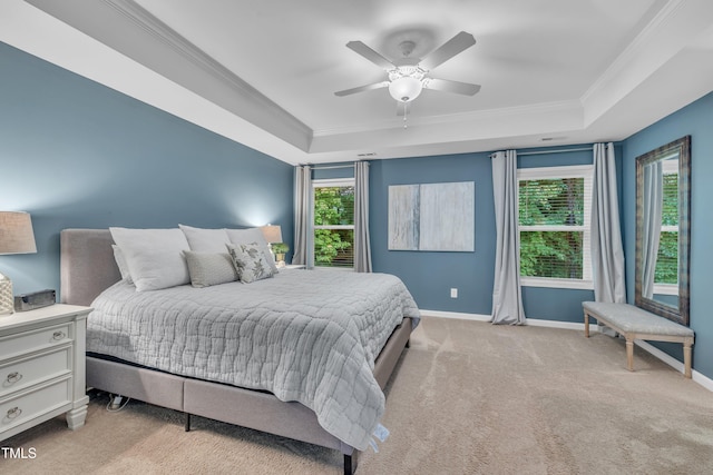 bedroom featuring a raised ceiling, ornamental molding, baseboards, light colored carpet, and multiple windows