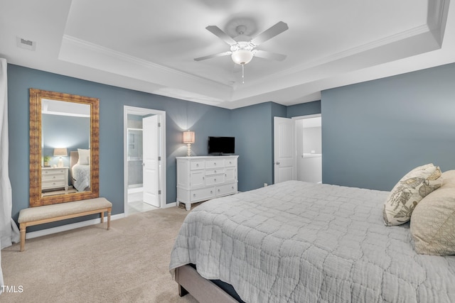 carpeted bedroom featuring a raised ceiling, crown molding, baseboards, ceiling fan, and ensuite bath