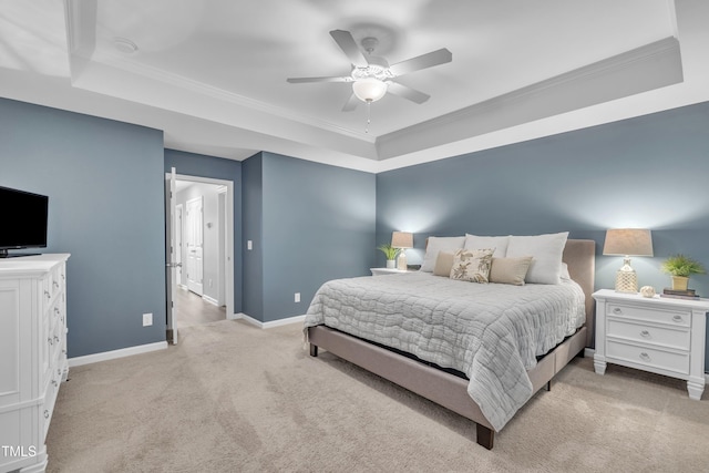 bedroom featuring a tray ceiling, light carpet, baseboards, ceiling fan, and ornamental molding