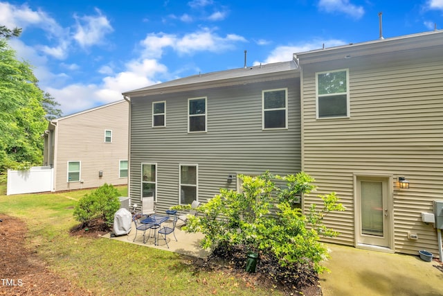 back of property with a patio area and a yard