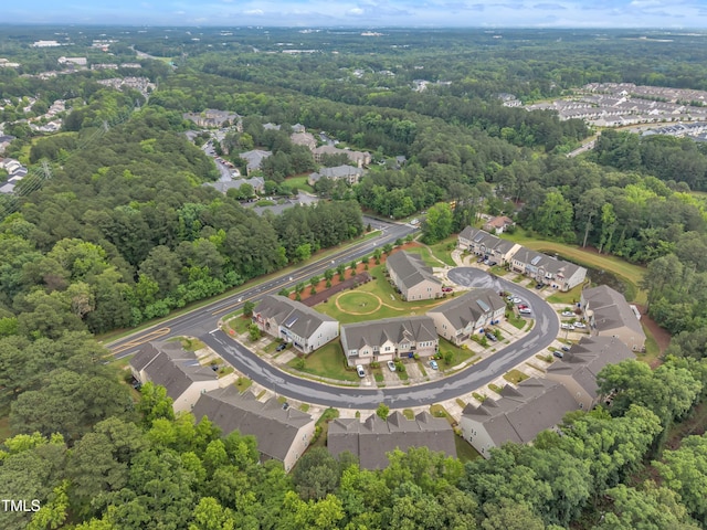 aerial view of property's location with a forest and nearby suburban area