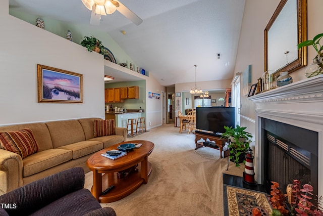 living room featuring a fireplace with flush hearth, light colored carpet, a ceiling fan, high vaulted ceiling, and a chandelier