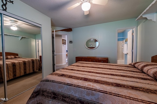 carpeted bedroom featuring a closet, ceiling fan, a textured ceiling, and ensuite bathroom