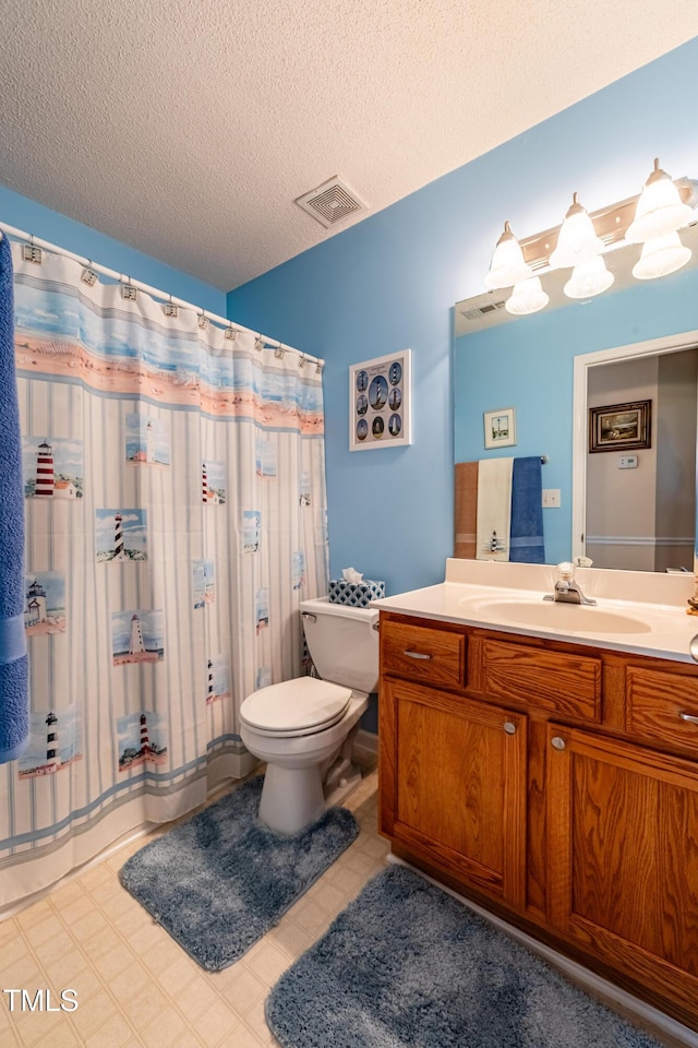full bathroom featuring toilet, vanity, and a textured ceiling