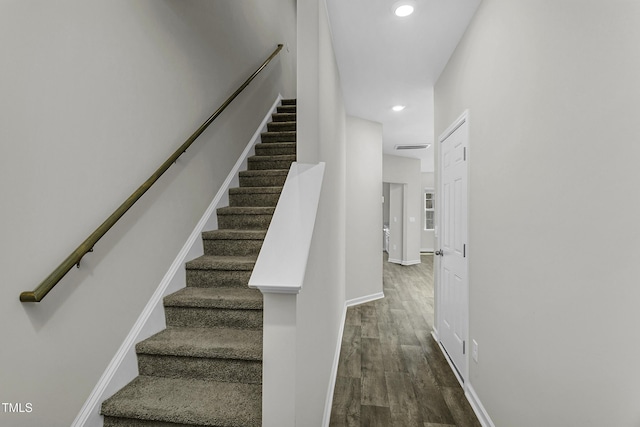 staircase with wood finished floors, recessed lighting, and baseboards