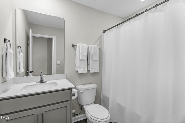 bathroom with toilet, vanity, and curtained shower