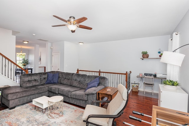 living room featuring wood finished floors, ceiling fan, stairs, a chandelier, and baseboards