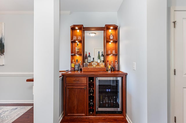indoor dry bar featuring beverage cooler, dark wood-style floors, ornamental molding, and baseboards
