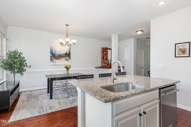 kitchen with a sink, dark wood-style floors, baseboards, a chandelier, and light stone counters