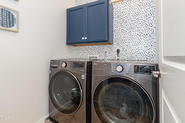 washroom featuring washing machine and clothes dryer and cabinet space