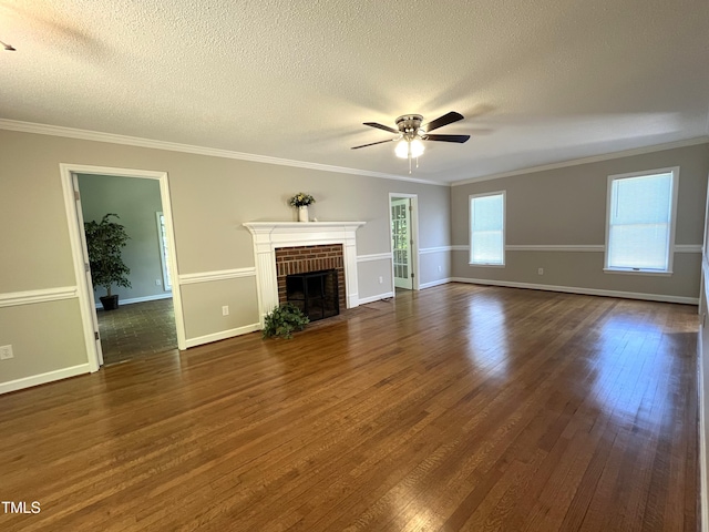 unfurnished living room with dark wood-type flooring, ceiling fan, a fireplace, a textured ceiling, and baseboards
