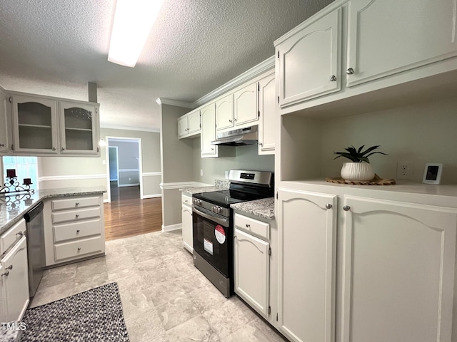 kitchen with stainless steel appliances, a textured ceiling, under cabinet range hood, crown molding, and glass insert cabinets