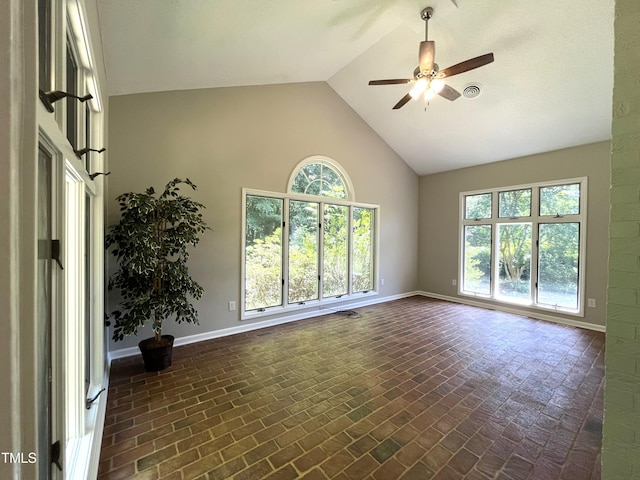spare room featuring ceiling fan, brick patterned floors, high vaulted ceiling, and baseboards