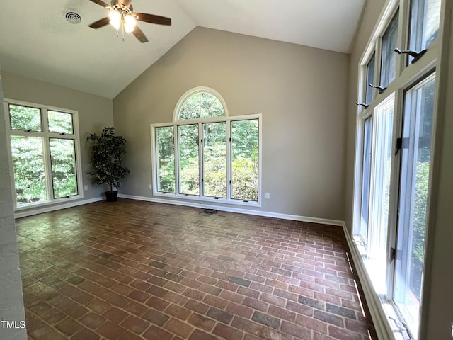 unfurnished room featuring high vaulted ceiling, ceiling fan, baseboards, and brick flooring