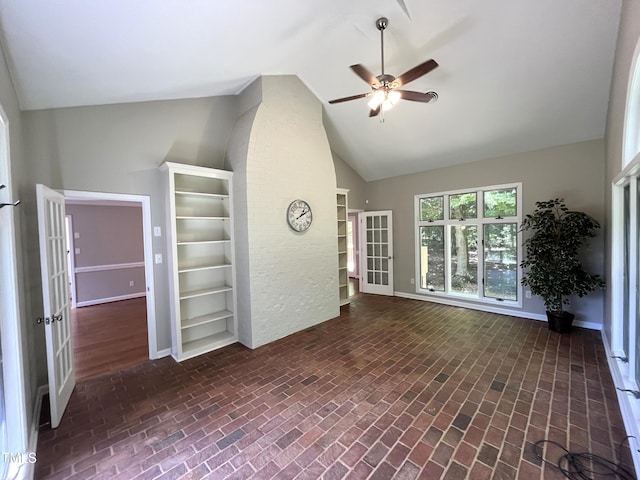 unfurnished living room featuring vaulted ceiling, ceiling fan, brick patterned floors, french doors, and baseboards