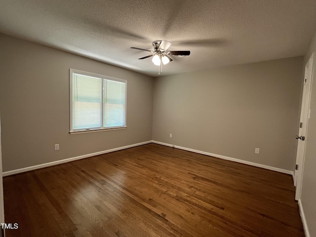 spare room featuring a ceiling fan, dark wood finished floors, baseboards, and a textured ceiling