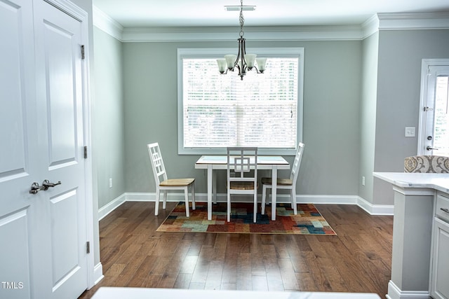 dining area featuring dark wood-style flooring, a chandelier, crown molding, plenty of natural light, and baseboards