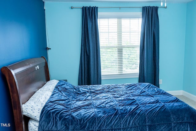 bedroom with baseboards and multiple windows