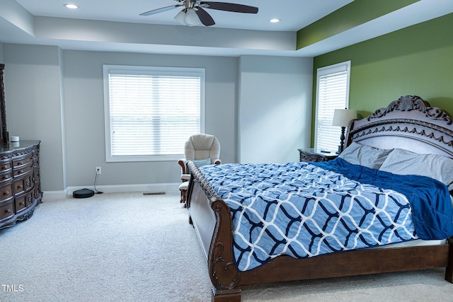 bedroom featuring carpet, baseboards, recessed lighting, ceiling fan, and a tray ceiling