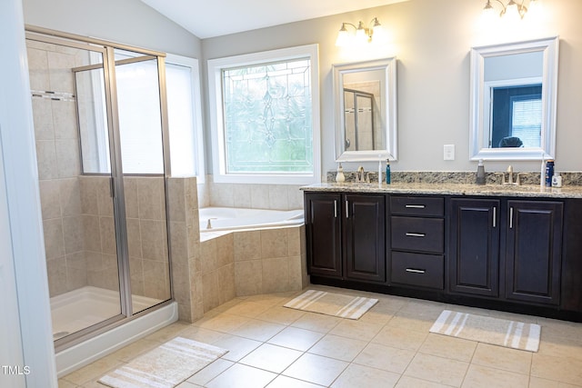 full bath featuring tile patterned floors, a shower stall, a garden tub, double vanity, and vaulted ceiling