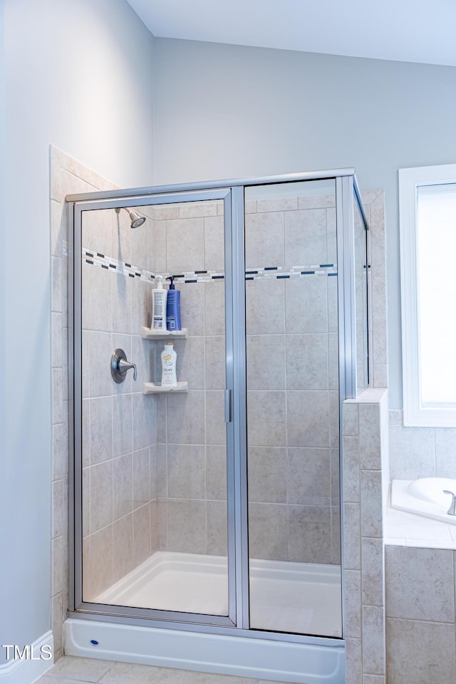 bathroom with a stall shower and a bath