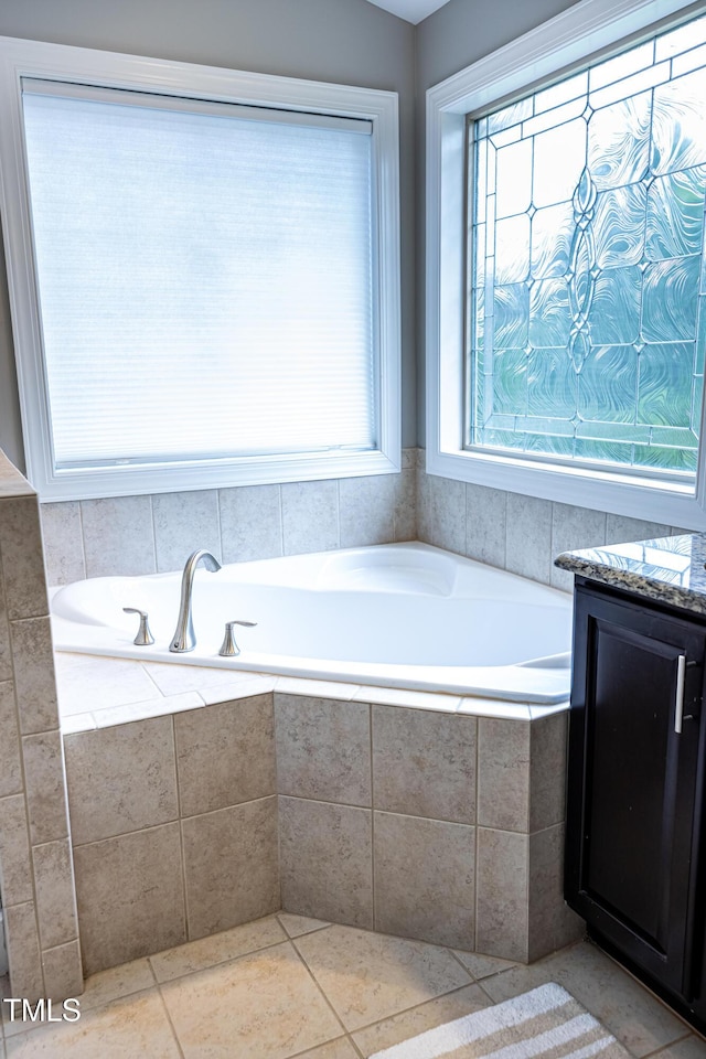 bathroom with a bath and tile patterned flooring