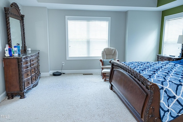 bedroom with baseboards, carpet floors, and multiple windows