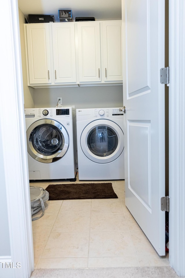 laundry room featuring cabinet space, washer and clothes dryer, and light tile patterned floors