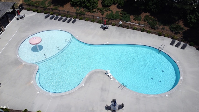 community pool with fence and a patio area