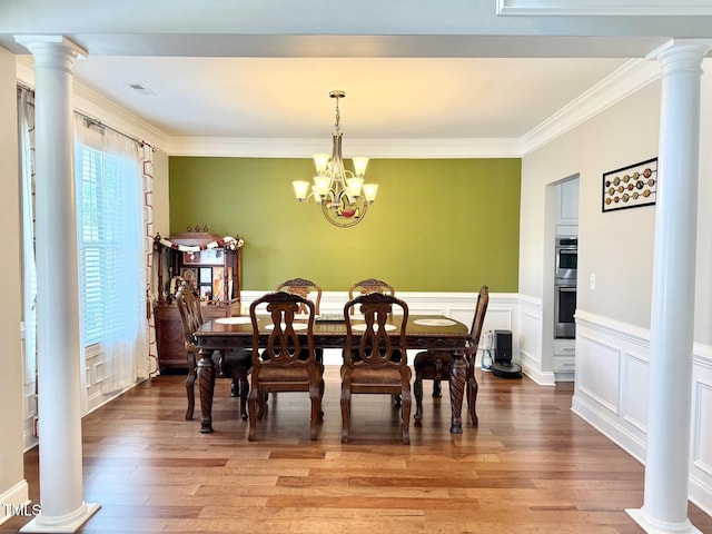 5016 Trembath Ln, Cary, NC 27519 - dining room with ornamental molding, hardwood / wood-style floors, a chandelier, decorative columns, and a decorative wall