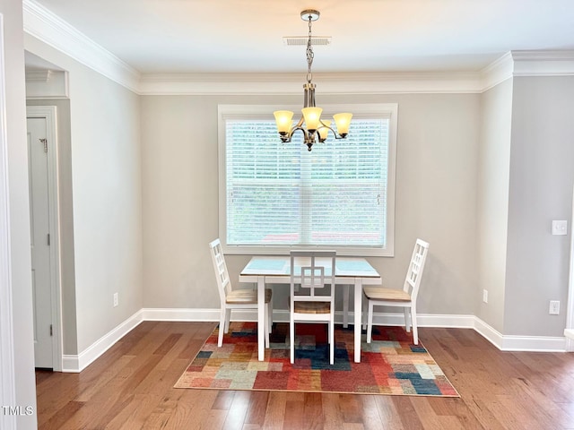 5016 Trembath Ln, Cary, NC 27519 - dining area with a chandelier, wood finished floors, baseboards, and crown molding