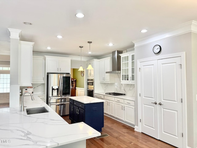 5016 Trembath Ln, Cary, NC 27519 - kitchen with appliances with stainless steel finishes, a sink, wall chimney range hood, white cabinets, and decorative backsplash