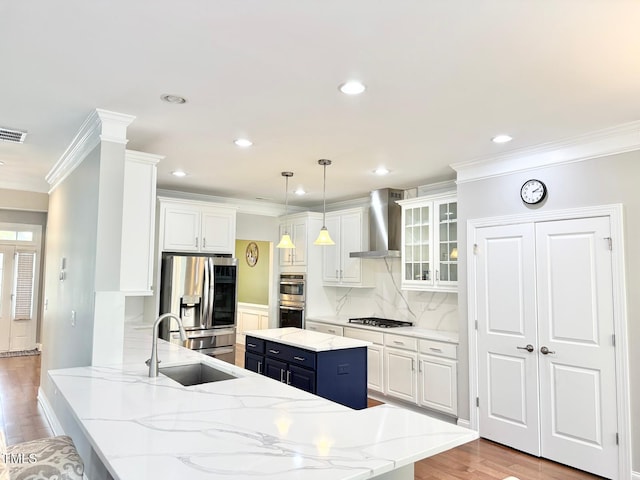 5016 Trembath Ln, Cary, NC 27519 - kitchen featuring wall chimney range hood, a sink, appliances with stainless steel finishes, white cabinets, and crown molding