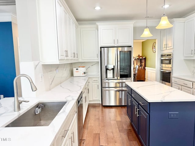 5016 Trembath Ln, Cary, NC 27519 - kitchen featuring stainless steel appliances, a sink, blue cabinets, white cabinets, and recessed lighting