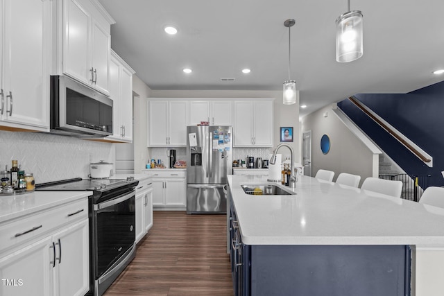 159 Wood Orchid Ln, Garner, NC 27529 - kitchen with appliances with stainless steel finishes, a sink, a kitchen island with sink, tasteful backsplash, and light countertops