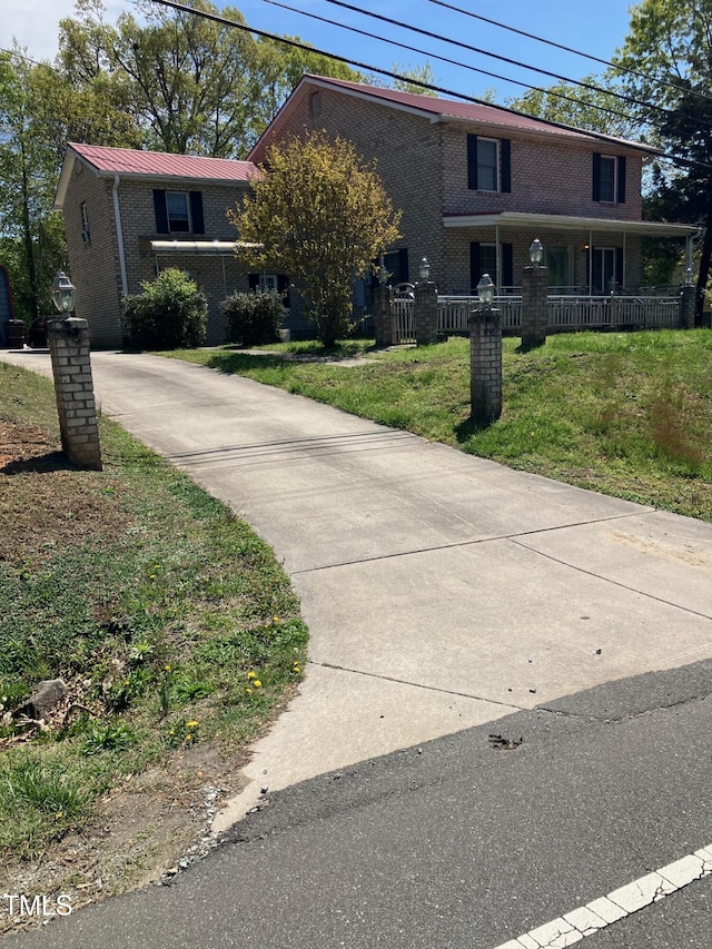 836 S Main St, Roxboro, NC 27573 - view of front of property featuring brick siding, a front lawn, metal roof, and a porch