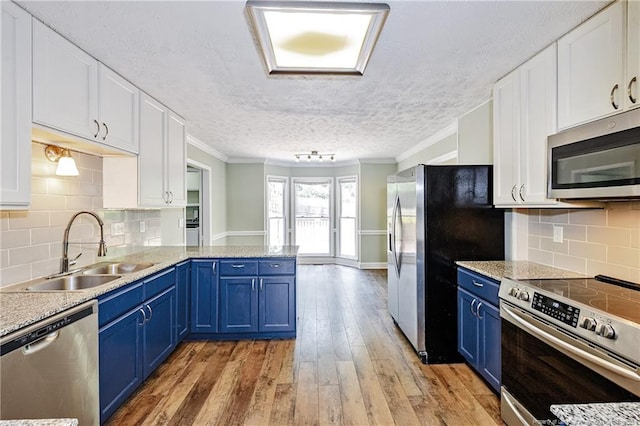 750 Magellan Ct, Fayetteville, NC 28311 - kitchen featuring stainless steel appliances, blue cabinets, crown molding, white cabinets, and a textured ceiling