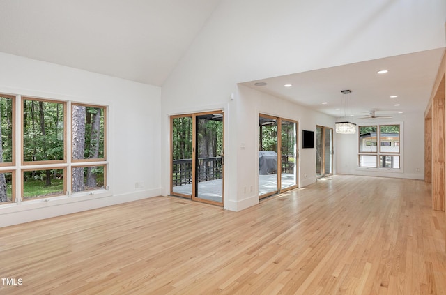 empty room with light wood finished floors, baseboards, high vaulted ceiling, ceiling fan, and recessed lighting