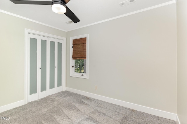 unfurnished bedroom featuring ornamental molding, carpet flooring, baseboards, a closet, and ceiling fan
