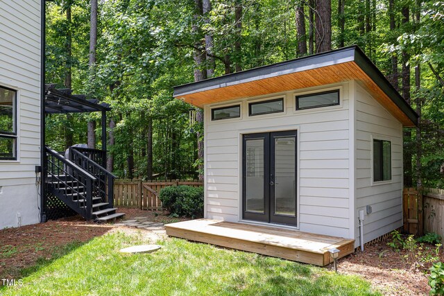 view of outbuilding featuring fence and an outdoor structure